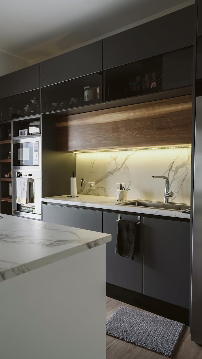Services Sleek and modern kitchen featuring dark cabinetry and ambient lighting.